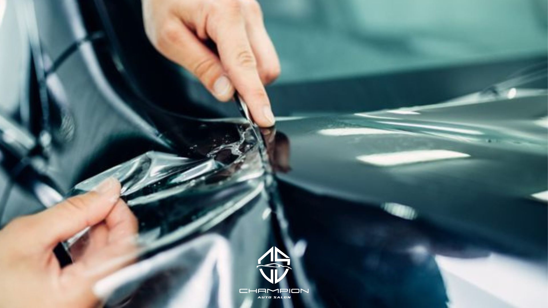 A close-up of a technician trimming paint protection film along the edge of a black car panel. Champion Auto Salon logo is visible.